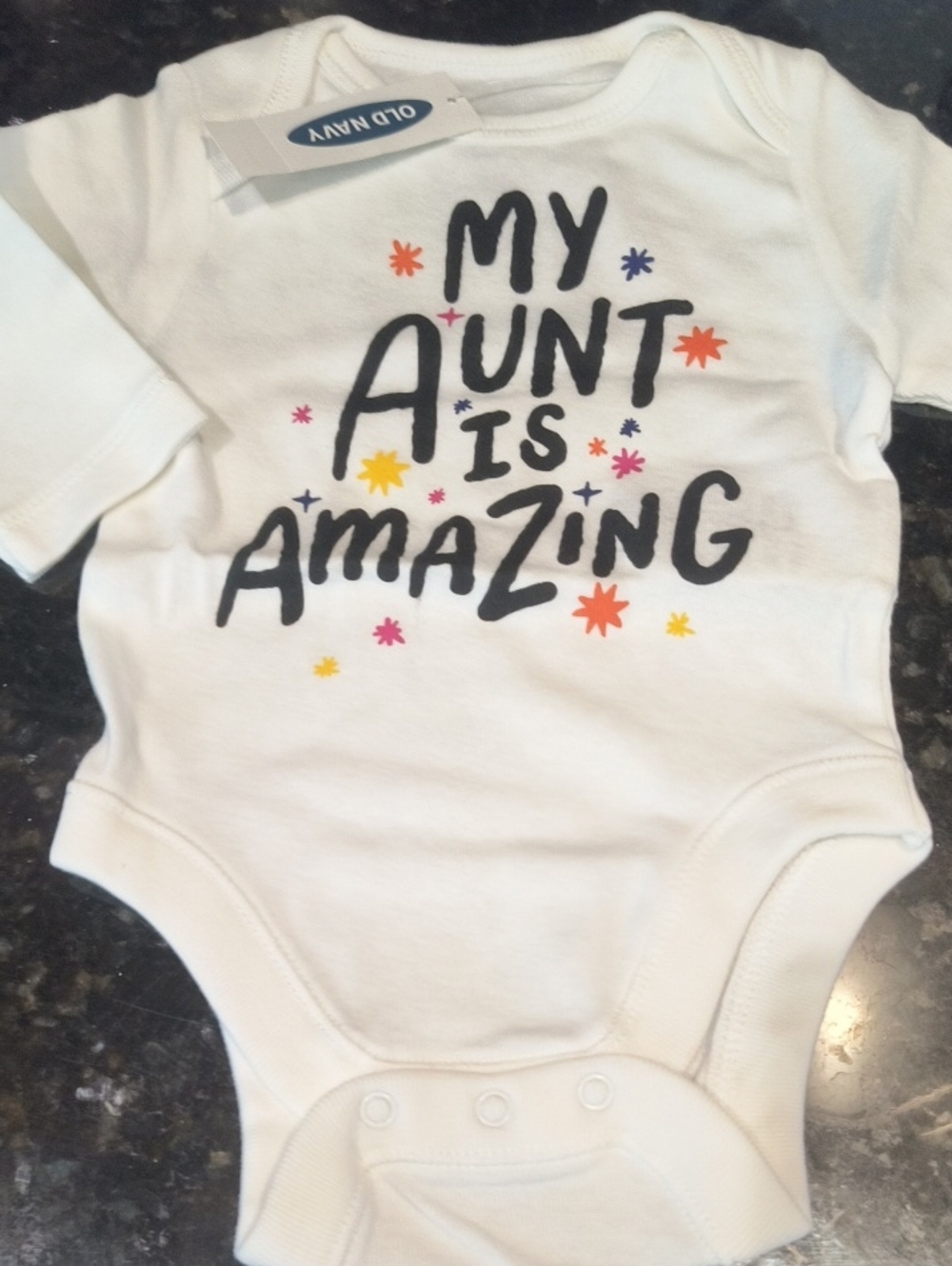 Old Navy White One-Piece Bodysuit with Black Text and Multi-Colored Stars